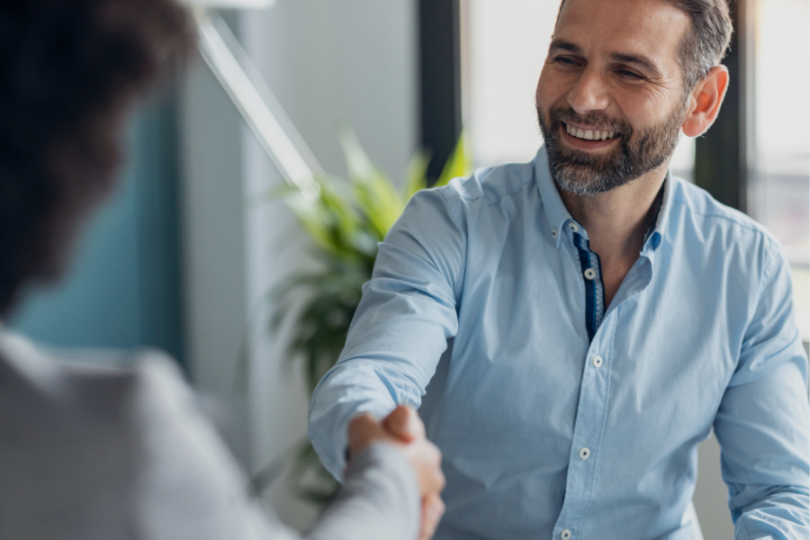 Professional man shaking hands in a business setting, demonstrating a successful agreement or partnership.